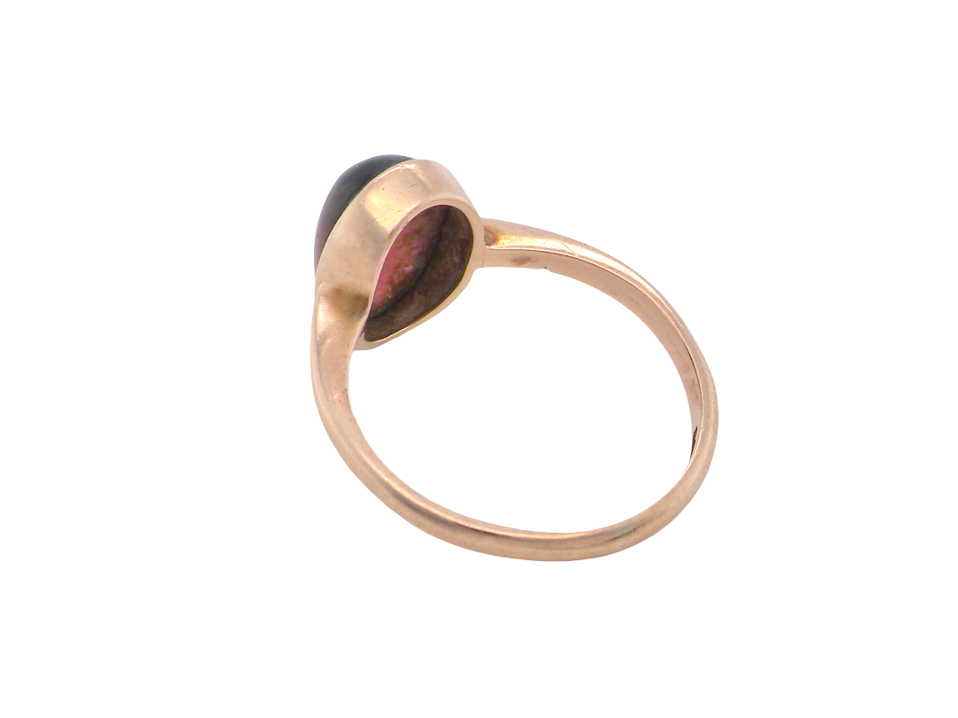 rear A vintage dress ring. Set with an oval cabouchon cut garnet, 11x7mm, in a rim style setting.