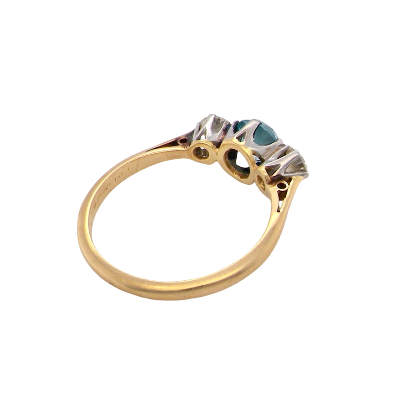 rear A vintage three stone ring. Centre stone, a round 5.8mm natural blue zircon.
To each side an old brilliant cut white diamond 4mm round (est 0.25 carats). Colour i-j, clarity Si.