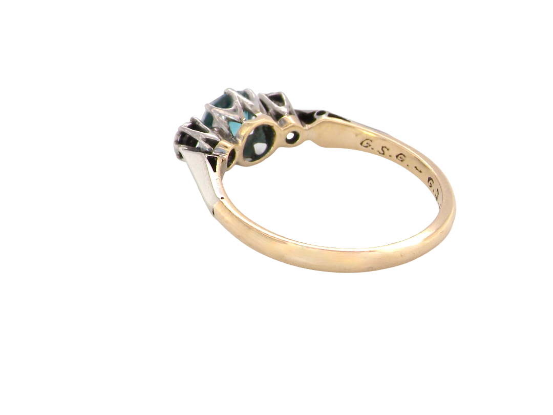 rear A vintage three stone ring. Features to the centre a 6mm natural blue zircon, 6mm diameter, claw set.