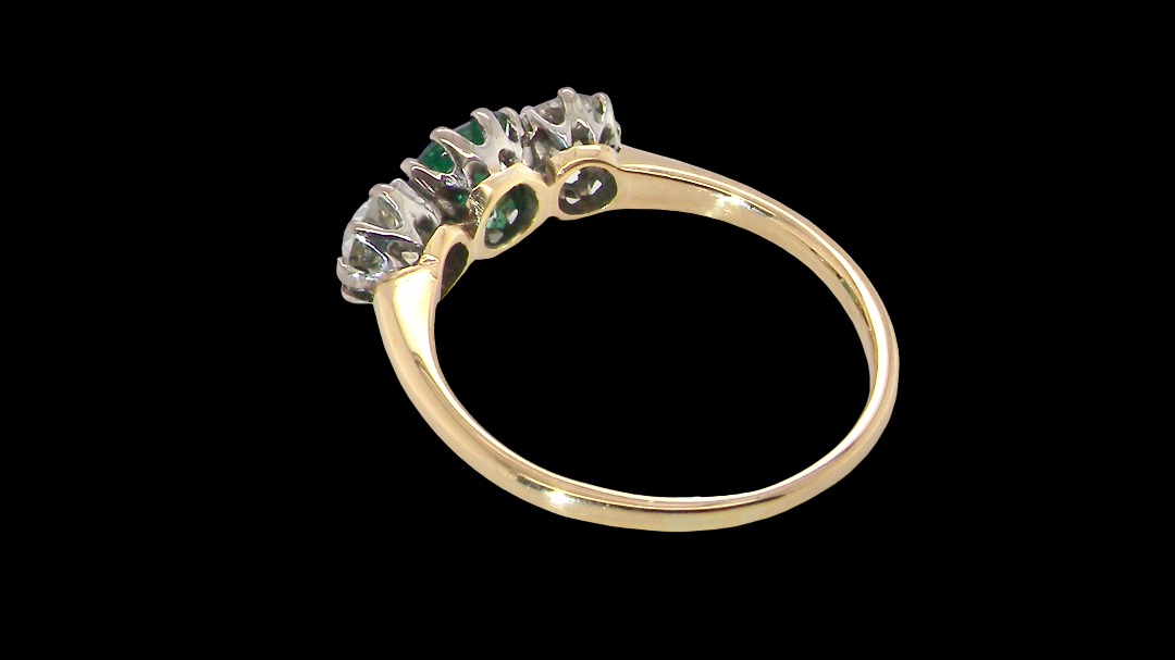 rear A vintage trilogy ring. Centre stone a step cut emerald, 6.5x5.5mm (est .75 carats). The emerald is dark green.