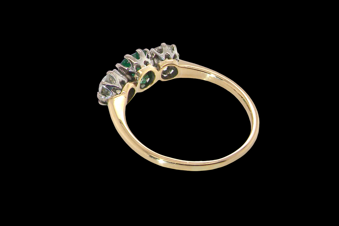 rear A vintage trilogy ring. Centre stone a step cut emerald, 6.5x5.5mm (est .75 carats). The emerald is dark green.