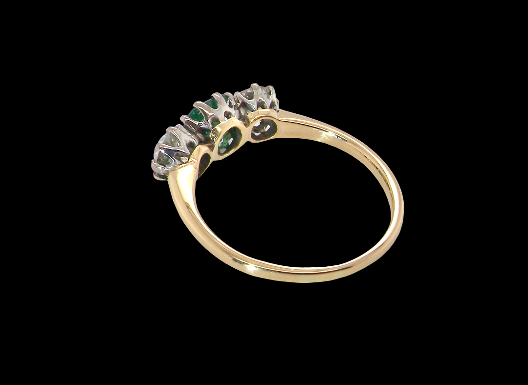 rear A vintage trilogy ring. Centre stone a step cut emerald, 6.5x5.5mm (est .75 carats). The emerald is dark green.
