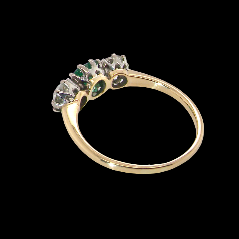 rear A vintage trilogy ring. Centre stone a step cut emerald, 6.5x5.5mm (est .75 carats). The emerald is dark green.
