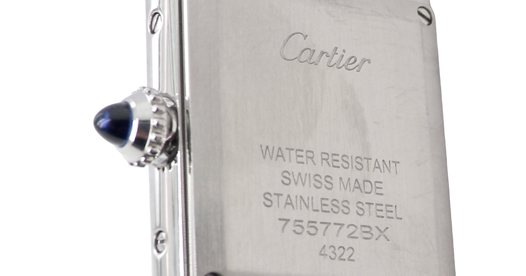 rear A womans stainless steel Cartier Tank Must wrist watch. Model number WSTA0051.
Silver coloured dial with Roman Numerals. Blue steeled hands. Case measures 29.5x22mm, case thickness 6.6mm. Quartz movement, synthetic sapphire button.