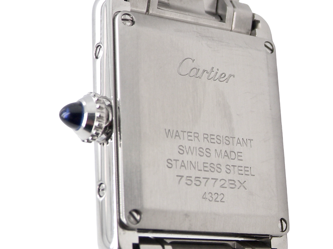 rear A womans stainless steel Cartier Tank Must wrist watch. Model number WSTA0051.
Silver coloured dial with Roman Numerals. Blue steeled hands. Case measures 29.5x22mm, case thickness 6.6mm. Quartz movement, synthetic sapphire button.