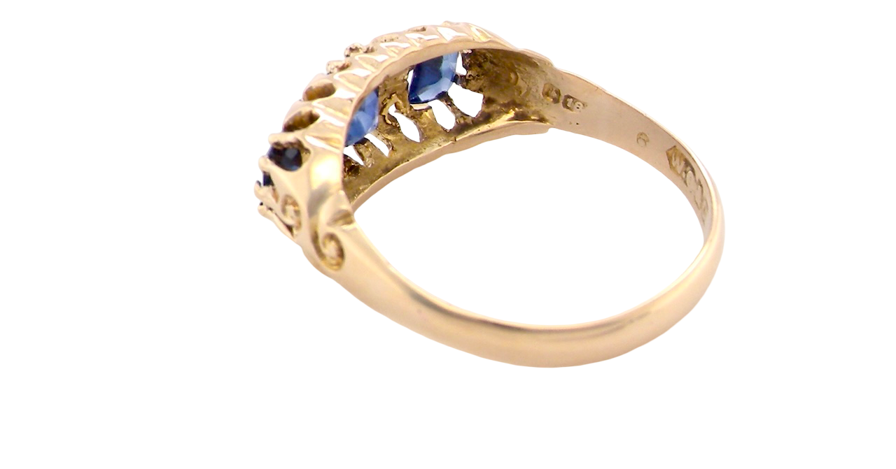 rear An 18 carat gold antique boat shaped ring. Features three oval to cushion cut sapphires, centre 6x5mm, each end 5x3mm. Mid to dark blue