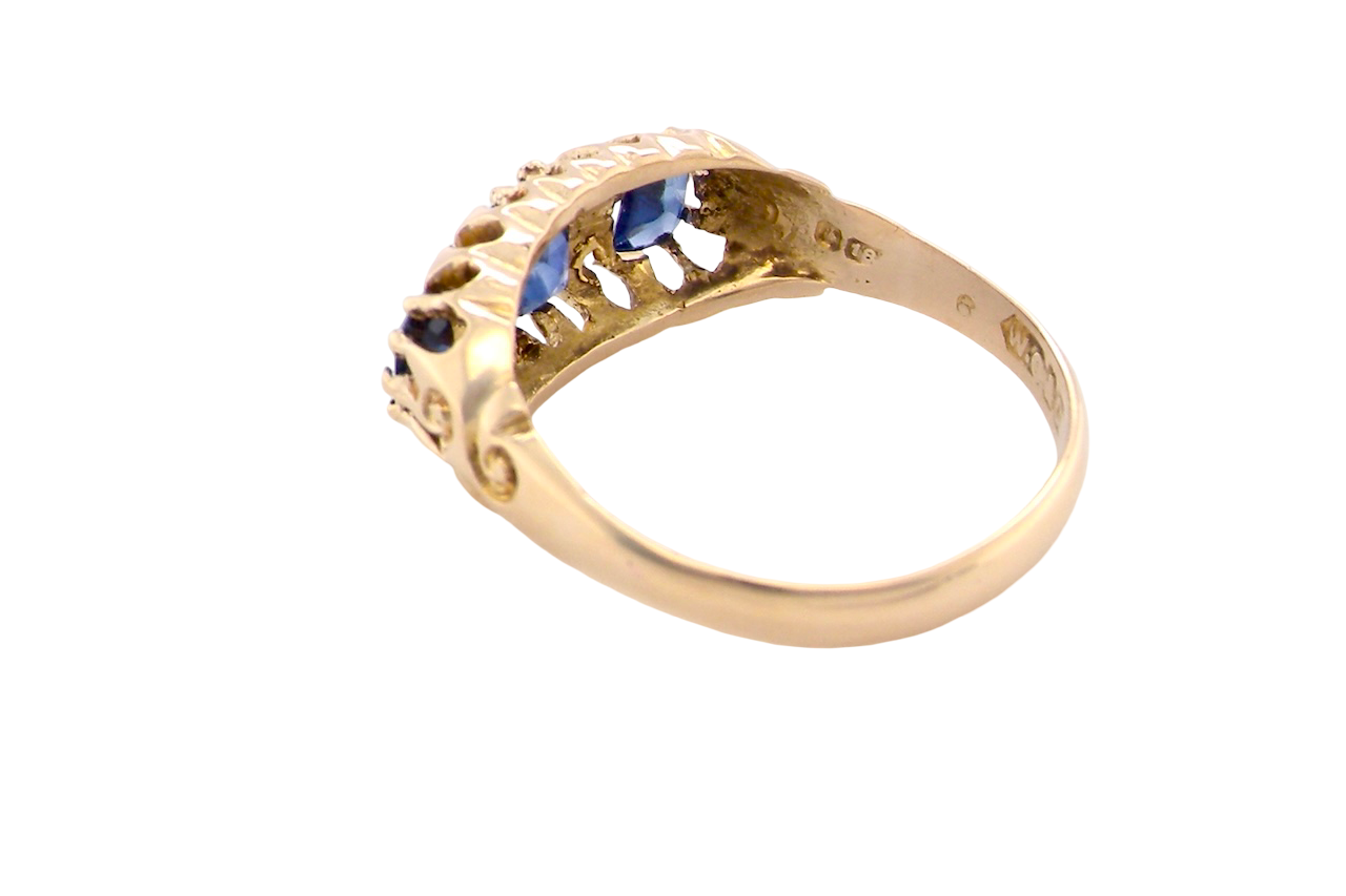 rear An 18 carat gold antique boat shaped ring. Features three oval to cushion cut sapphires, centre 6x5mm, each end 5x3mm. Mid to dark blue