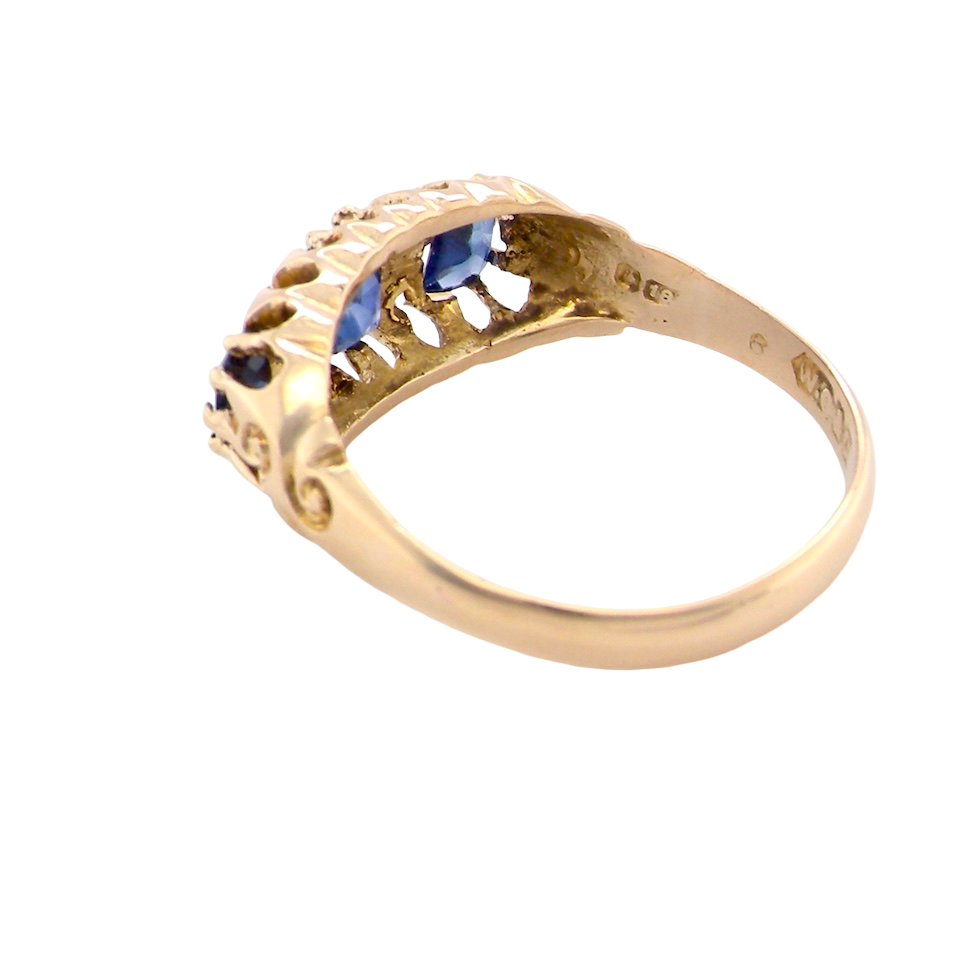 rear An 18 carat gold antique boat shaped ring. Features three oval to cushion cut sapphires, centre 6x5mm, each end 5x3mm. Mid to dark blue