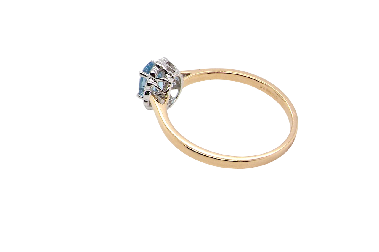 rear An 18 carat gold cluster ring. Set to the centre a lovely ice blue aquamarine 6x4mm, claw set.