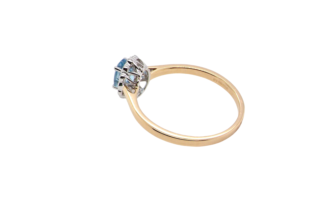 rear An 18 carat gold cluster ring. Set to the centre a lovely ice blue aquamarine 6x4mm, claw set.
