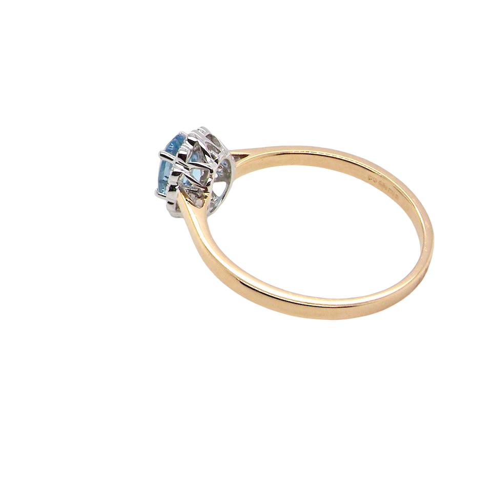 rear An 18 carat gold cluster ring. Set to the centre a lovely ice blue aquamarine 6x4mm, claw set.