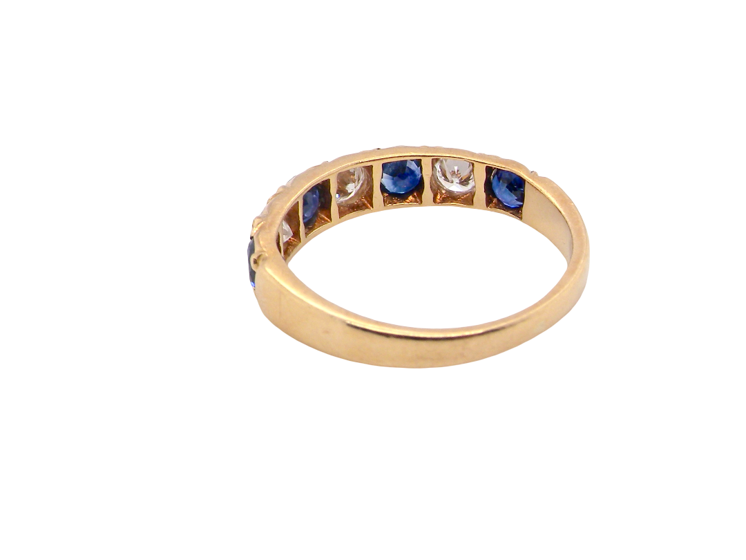 rear An 18 carat gold half hoop eternity ring. Set with four sapphires each 3.4mm (0.15 carats) and three diamonds, brilliant cut, 3.4mm (0.15 carats).