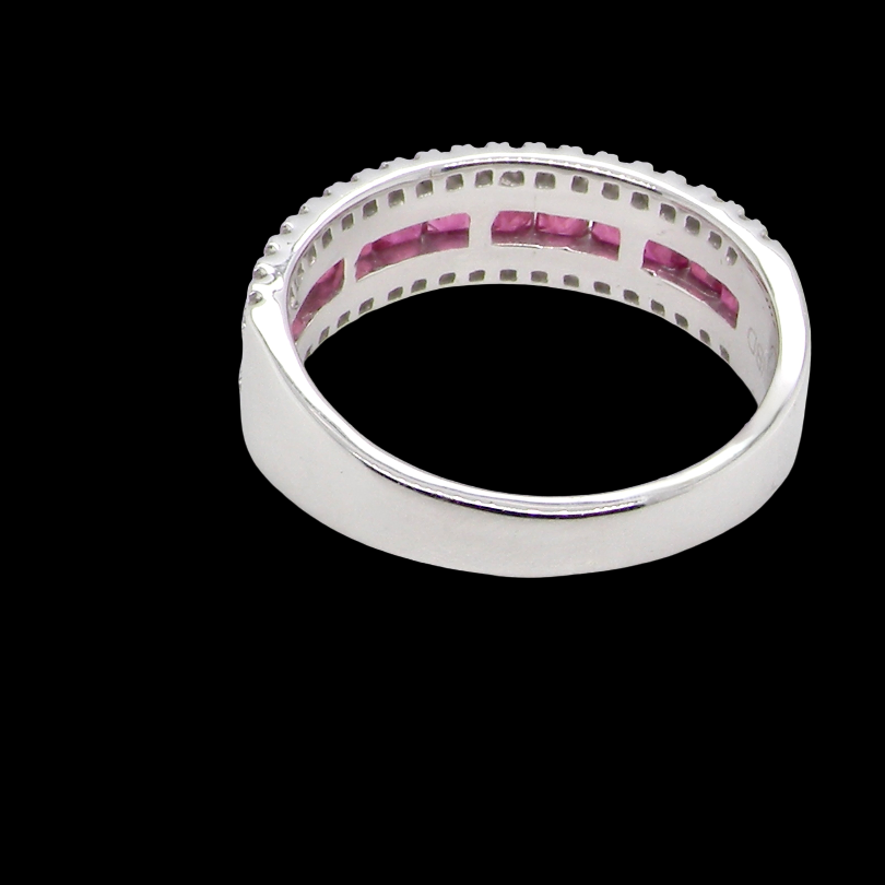 rear An 18 carat white gold half hoop ring. A triple row design with a line of channel set calibre cut rubies running along the centre , to a total carat weight of 0.97 carats.