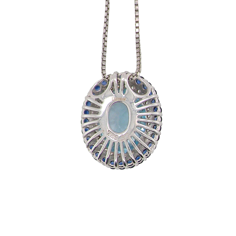 rear An 18 carat white gold oval shaped pendant. Features an oval cut blue topaz centre stone, 13x9mm.
Complimented by an outer halo of approximately thirty small brilliant cut white diamonds,