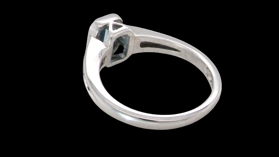 rear An 18 carat white gold ring, features a rectangular step cut aquamarine, measures 7x5mm (st one carat) sky blue, fine clarity. Rim setting.