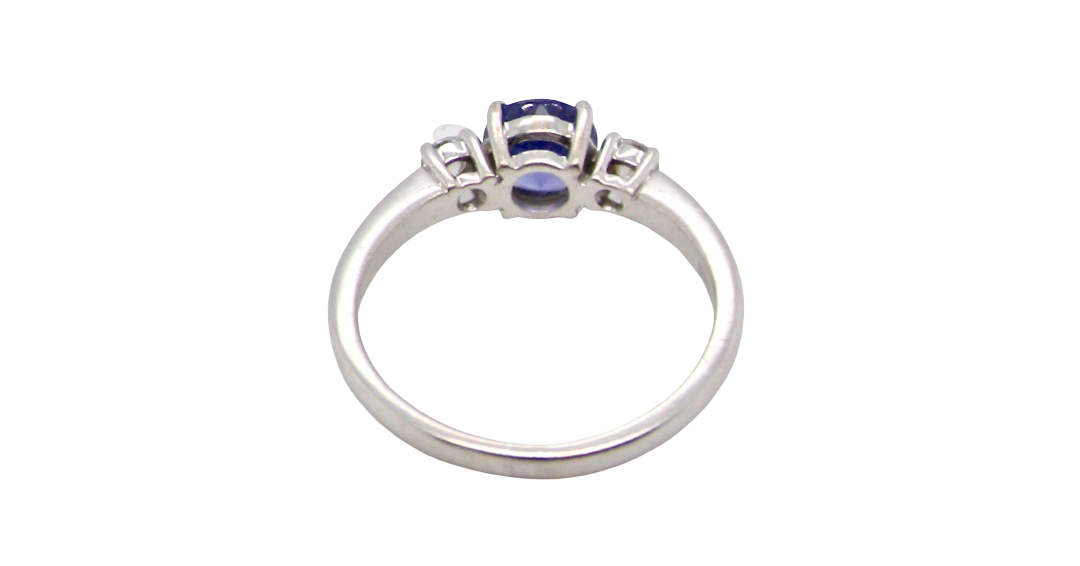 rear An 18 carat white gold three stone ring. Centre stone a round tanzanite 6mm diameter.
Each side a brilliant cut white diamond