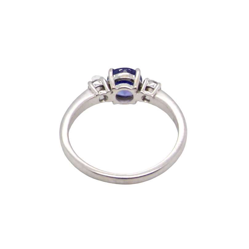 rear An 18 carat white gold three stone ring. Centre stone a round tanzanite 6mm diameter.
Each side a brilliant cut white diamond