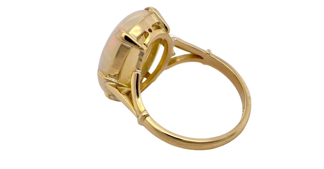 rear An 18 carat yellow gold* dress ring set with a large oval opal gemstone.