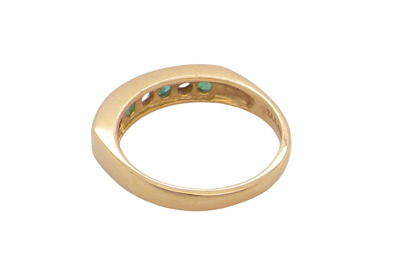 rear An 18 carat yellow gold half hoop eternity ring. Set with four round emeralds, each 3mm, and alternate set with brilliant cut white diamonds, each 3mm (total est 0.30 carats)