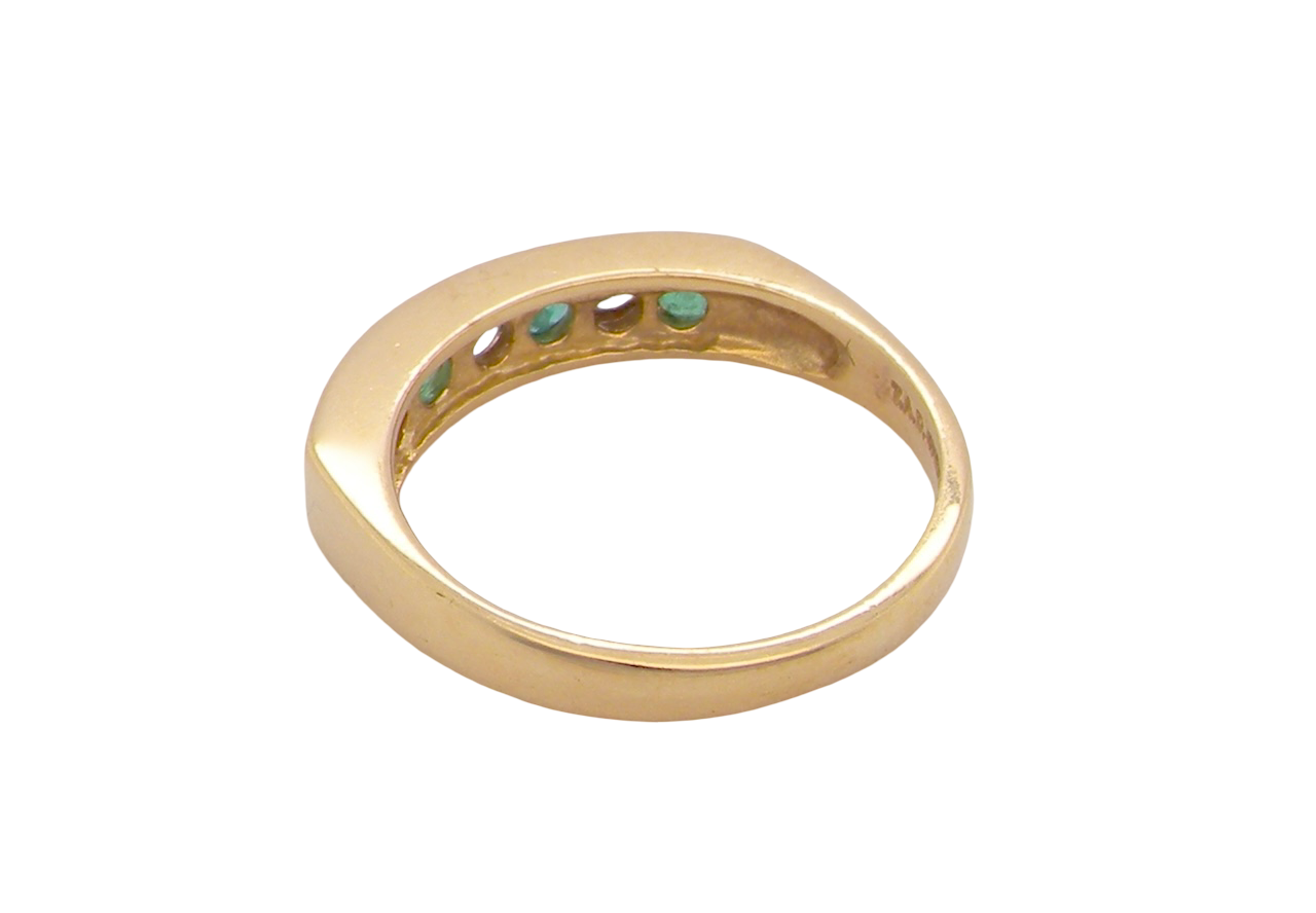rear An 18 carat yellow gold half hoop eternity ring. Set with four round emeralds, each 3mm, and alternate set with brilliant cut white diamonds, each 3mm (total est 0.30 carats)