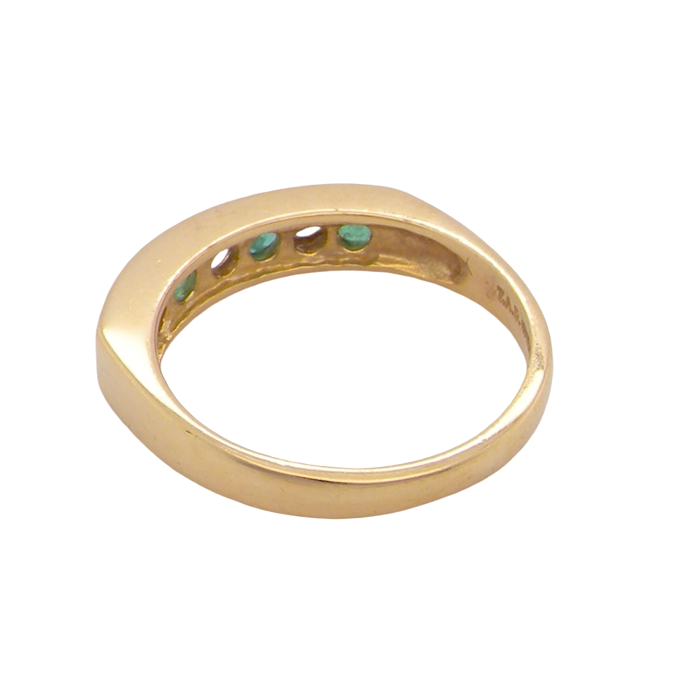 rear An 18 carat yellow gold half hoop eternity ring. Set with four round emeralds, each 3mm, and alternate set with brilliant cut white diamonds, each 3mm (total est 0.30 carats)