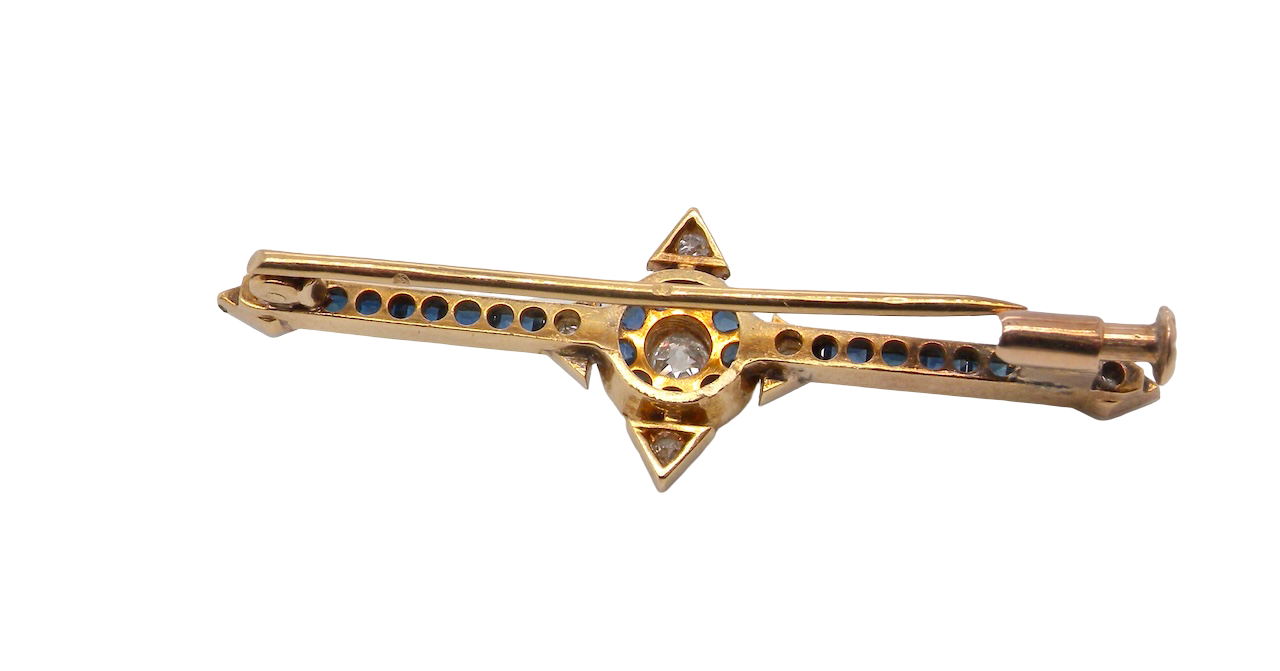 rear An Edwardian bar brooch. The centre 'target' style portion is set with a brilliant cut white diamond 4mm (0.25 carats) colour H-j, clarity Si. Mille grain setting.