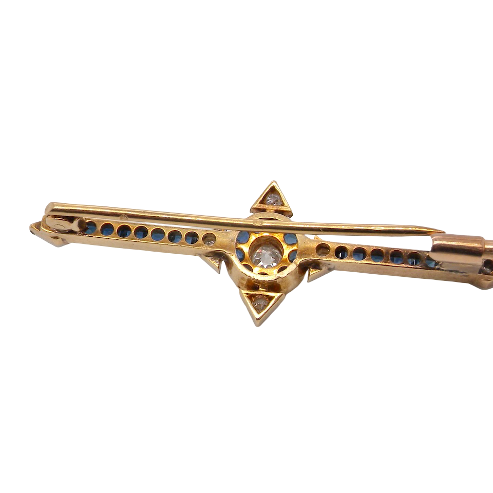 rear An Edwardian bar brooch. The centre 'target' style portion is set with a brilliant cut white diamond 4mm (0.25 carats) colour H-j, clarity Si. Mille grain setting.