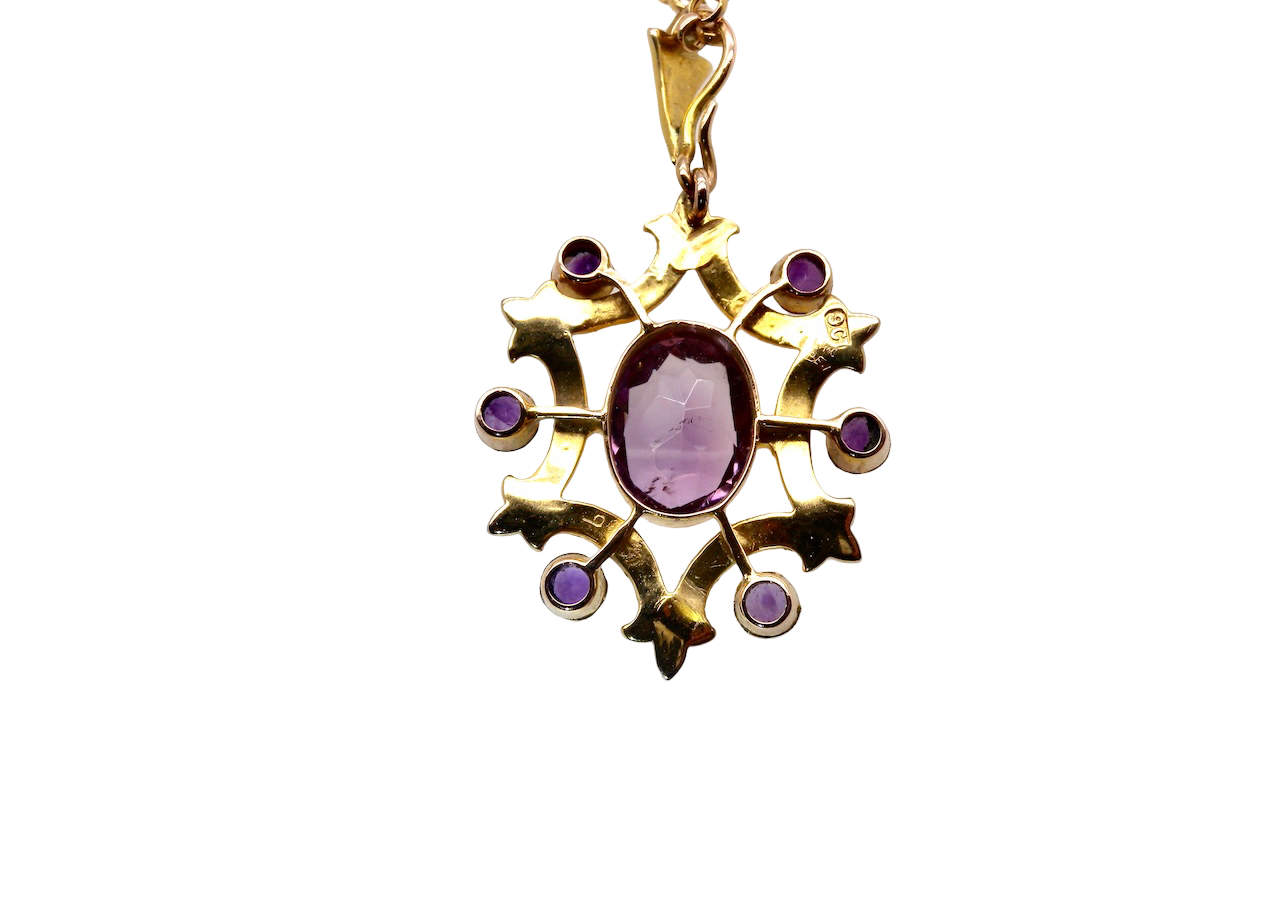 Gold pendant with a purple gemstone on a white background