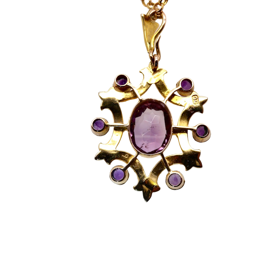 Gold pendant with a purple gemstone on a white background