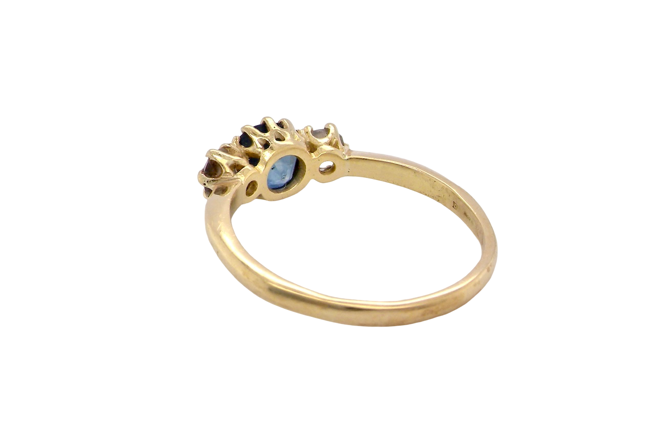 rear An early 20th-century trilogy ring set with a mid to dark cornflower blue central sapphire,