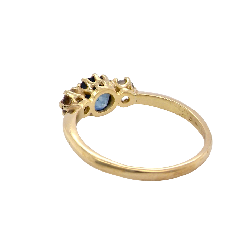 rear An early 20th-century trilogy ring set with a mid to dark cornflower blue central sapphire,