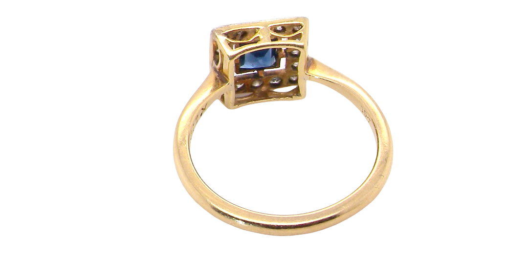 rear An early 20th century square cluster ring. Features a square inky black blue sapphire, 4x4mm (est 0.25 carats) mille grain set.