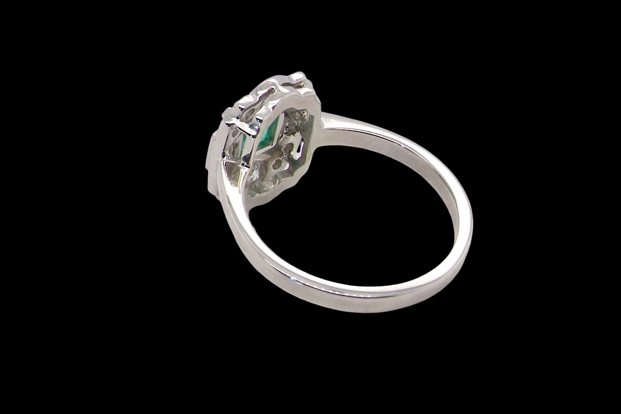 rear An elegant Art Deco–style cluster ring of plaque design, centred with a square step-cut emerald measuring approximately 4.5 × 4.5 mm (estimated 0.40 carats). The emerald displays a vibrant, lively green colour and is beautifully framed by diamonds.