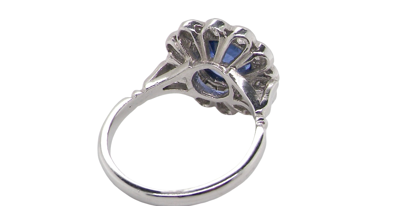 rear An elegant and timeless cluster ring, centrally set with a beautiful mid to deep blue cushion-cut sapphire, measuring approximately 8 x 8mm (estimated 2.00 carats).