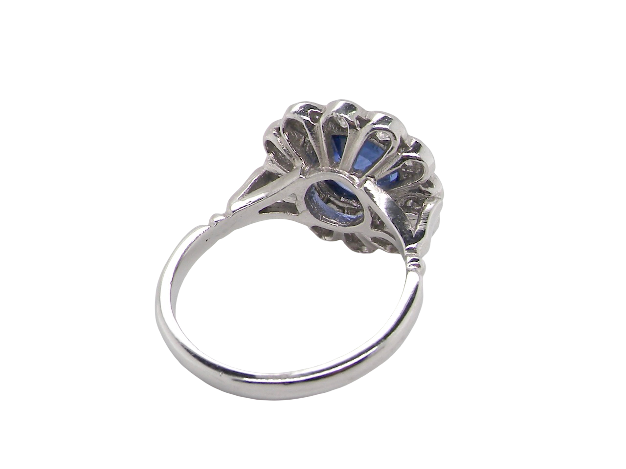 rear An elegant and timeless cluster ring, centrally set with a beautiful mid to deep blue cushion-cut sapphire, measuring approximately 8 x 8mm (estimated 2.00 carats).