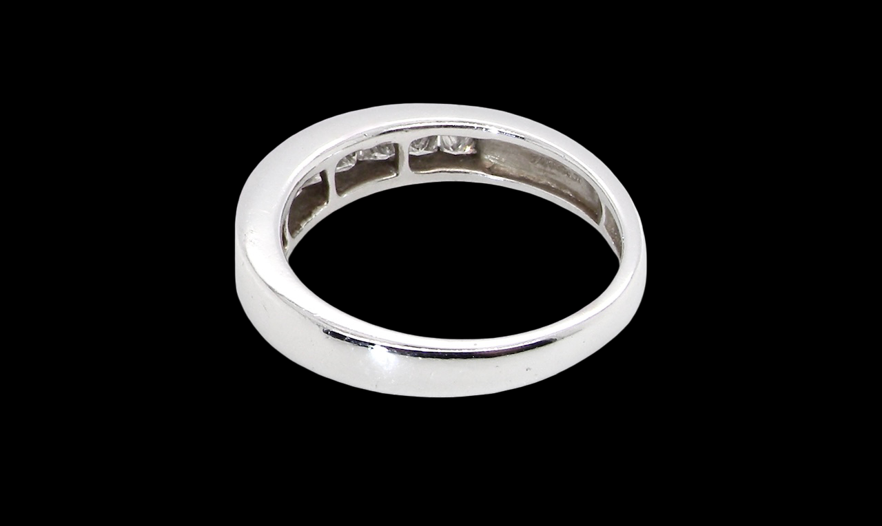 rear An elegant half-hoop eternity ring set with nine princess-cut white diamonds, each measuring approximately 2.5mm, with a total estimated diamond weight of 0.90 carats.