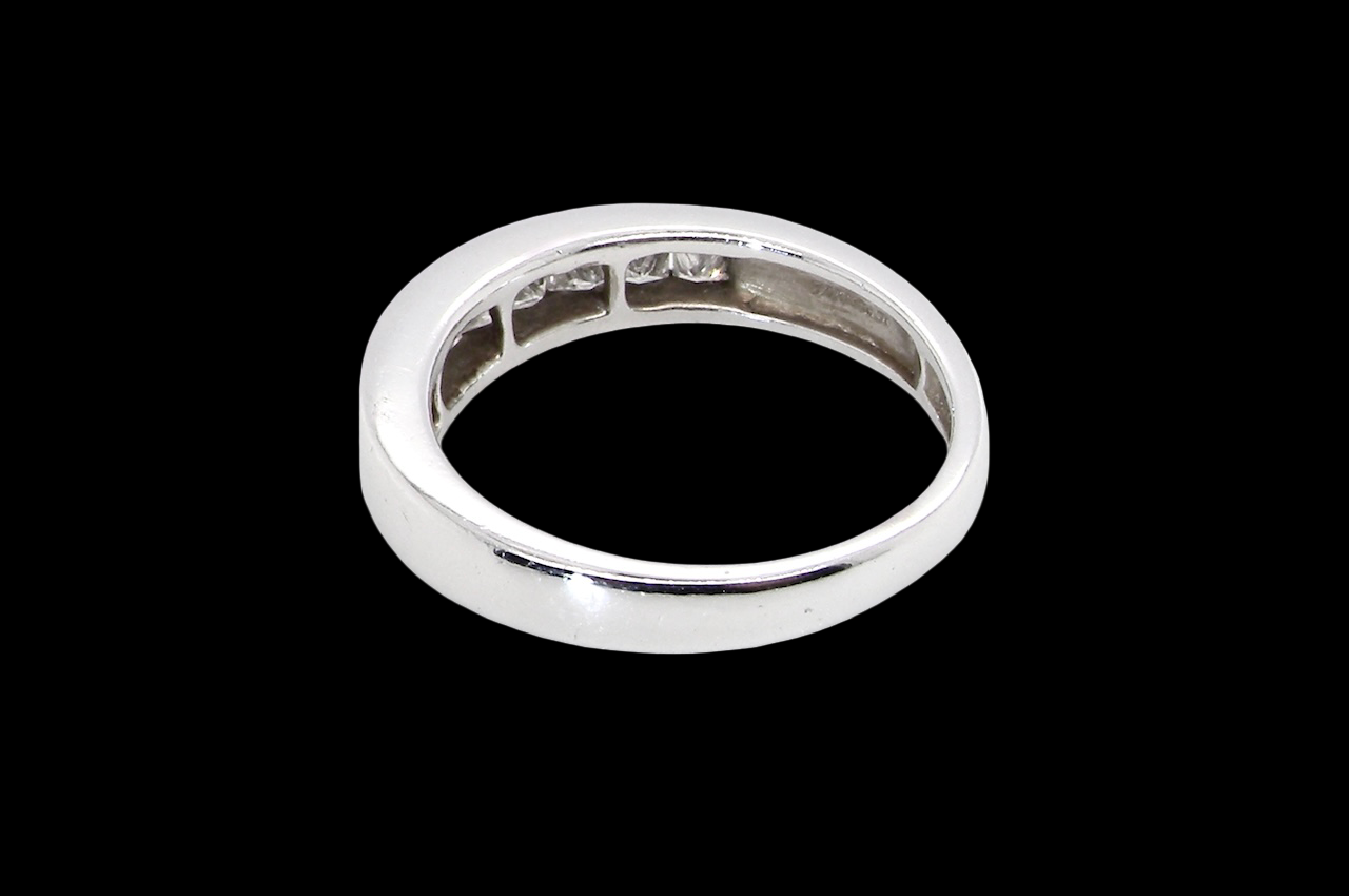rear An elegant half-hoop eternity ring set with nine princess-cut white diamonds, each measuring approximately 2.5mm, with a total estimated diamond weight of 0.90 carats.