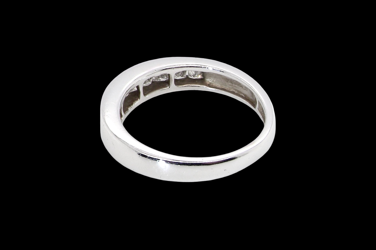 rear An elegant half-hoop eternity ring set with nine princess-cut white diamonds, each measuring approximately 2.5mm, with a total estimated diamond weight of 0.90 carats.