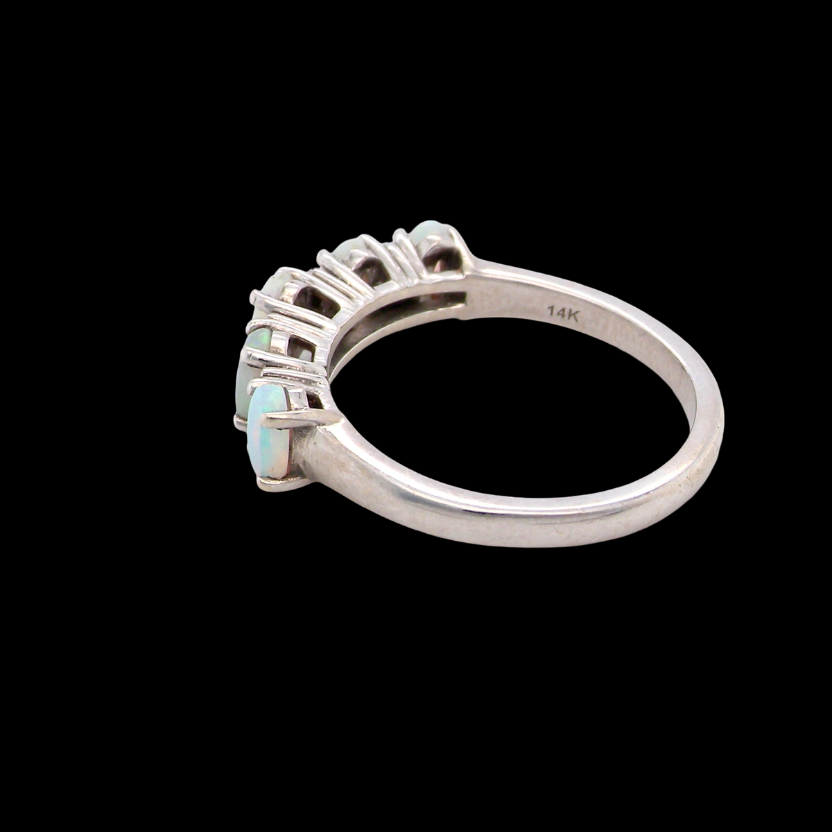 rear An elegant opal and diamond half hoop ring, featuring five oval opals with lively play of colour. Each opal measures 5 x 3mm, with an estimated total opal weight of approximately 0.75 carats, all claw set to maximise light and colour.