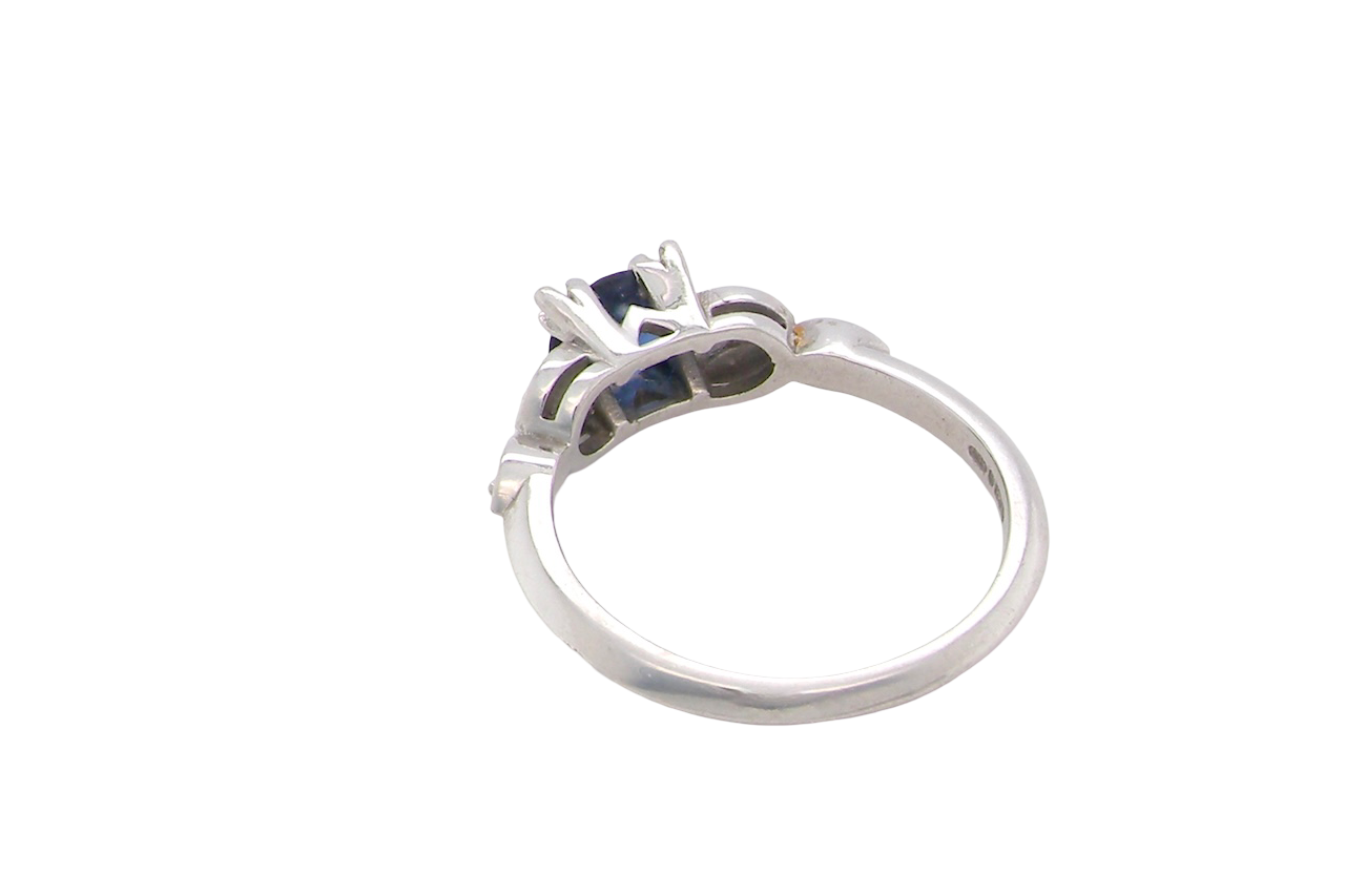 rear An elegant vintage-style platinum ring showcasing a beautifully proportioned round sapphire with a soft mid to light cornflower blue hue. The sapphire measures 5.6mm in diameter (approx. 0.80 carats)