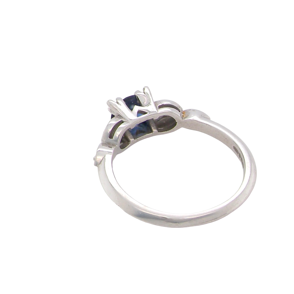 rear An elegant vintage-style platinum ring showcasing a beautifully proportioned round sapphire with a soft mid to light cornflower blue hue. The sapphire measures 5.6mm in diameter (approx. 0.80 carats)
