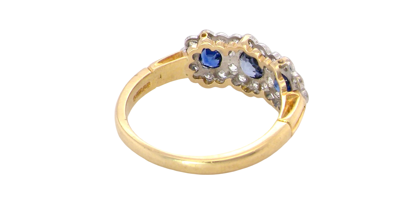 rear An impressive multi cluster ring. Set with three cornflower blue sapphires to each centre, 4.3mm, and each side a 3.3mm sapphire. Based on an Edwardian design