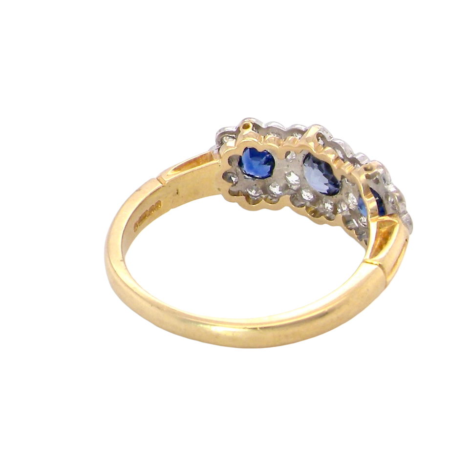 rear An impressive multi cluster ring. Set with three cornflower blue sapphires to each centre, 4.3mm, and each side a 3.3mm sapphire. Based on an Edwardian design