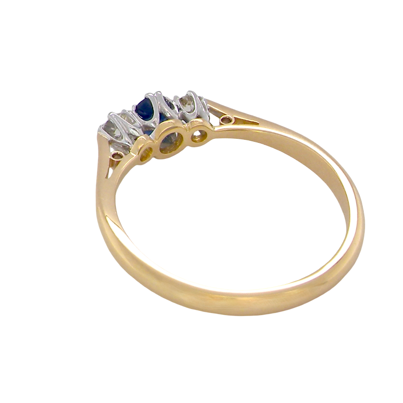 rear The classic trilogy ring, this features to the centre a round mid to dark blue sapphire and each side a brilliant cut white diamond