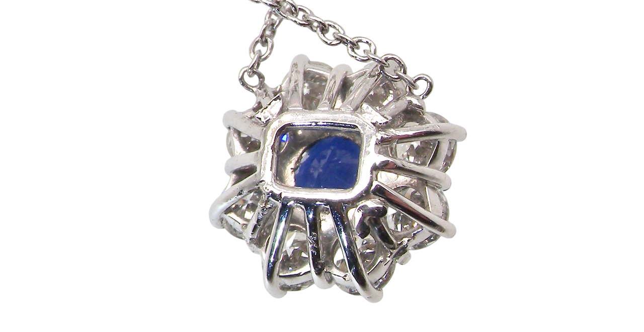 rear beautiful new 18 carat white gold cluster pendant, showcasing a vibrant blue sapphire at its centre.