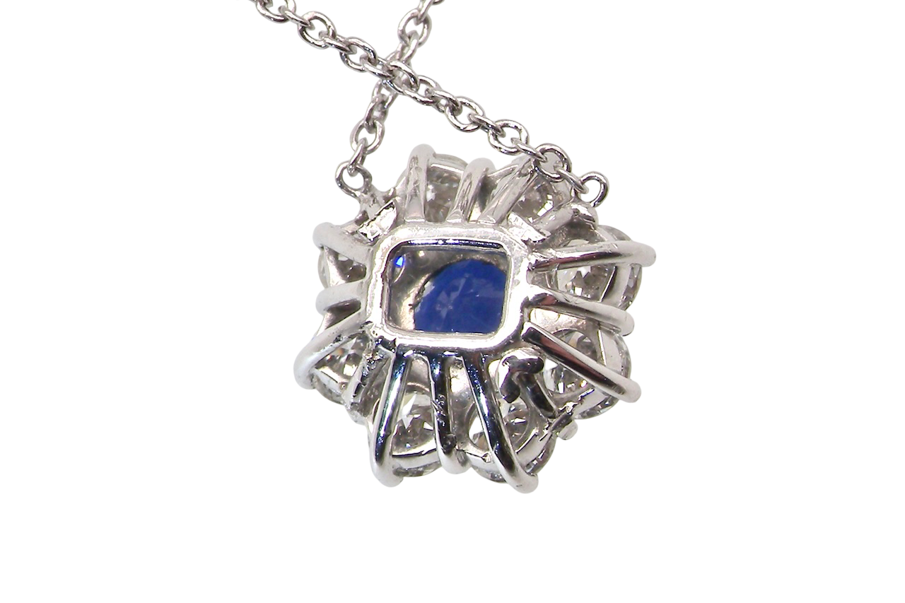 rear beautiful new 18 carat white gold cluster pendant, showcasing a vibrant blue sapphire at its centre.