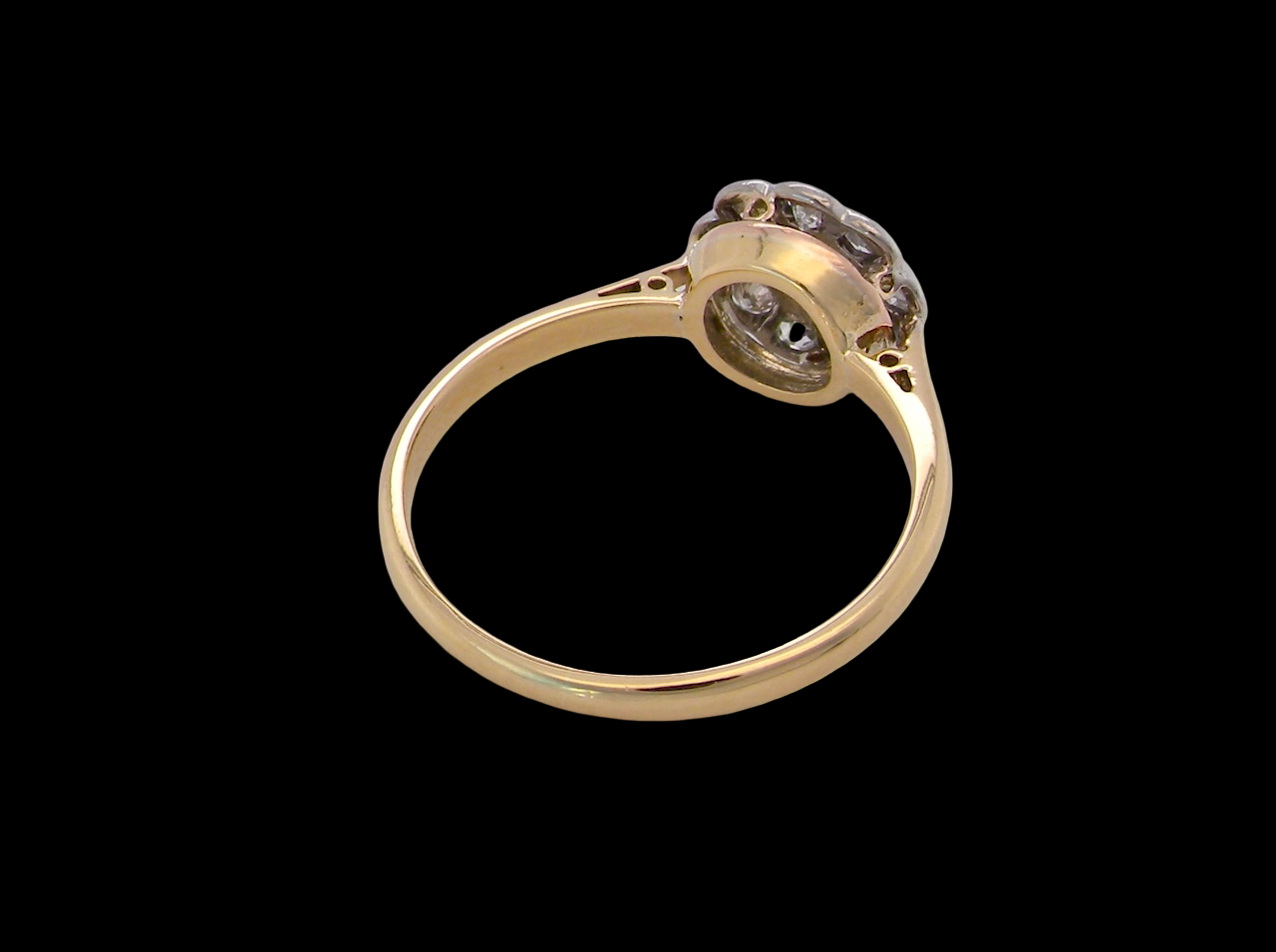 rear early 20th-century vintage diamond cluster ring, featuring a classic daisy-shaped head set with nine old brilliant-cut white diamonds.