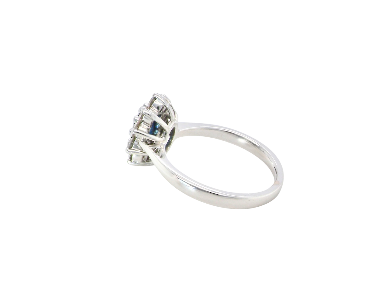 rear fine 18 carat white gold cluster ring. Features an oval cut dark blue sapphire centre stone