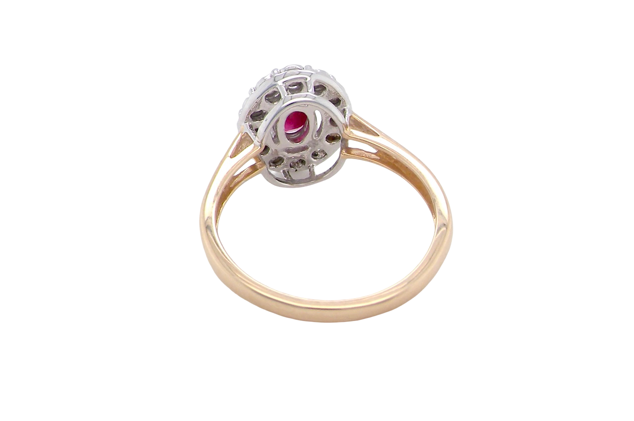 rear oval ruby measuring 6x4mm (approx. 0.44 carats) in a raspberry red hue. The centre stone is accented by a halo of twelve white diamonds