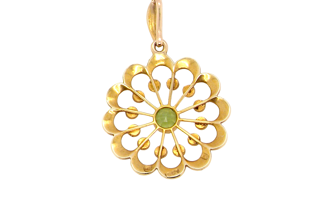 rear pendant from the Edwardian- Age of Elegance-
The centre stone- a round peridot 5mm diameter, mille grain set. A satellite perimeter of twelve seed pearls, each 2.4mm. The outside border is scalloped shaped and each crescent is set with tiny seed pearls.